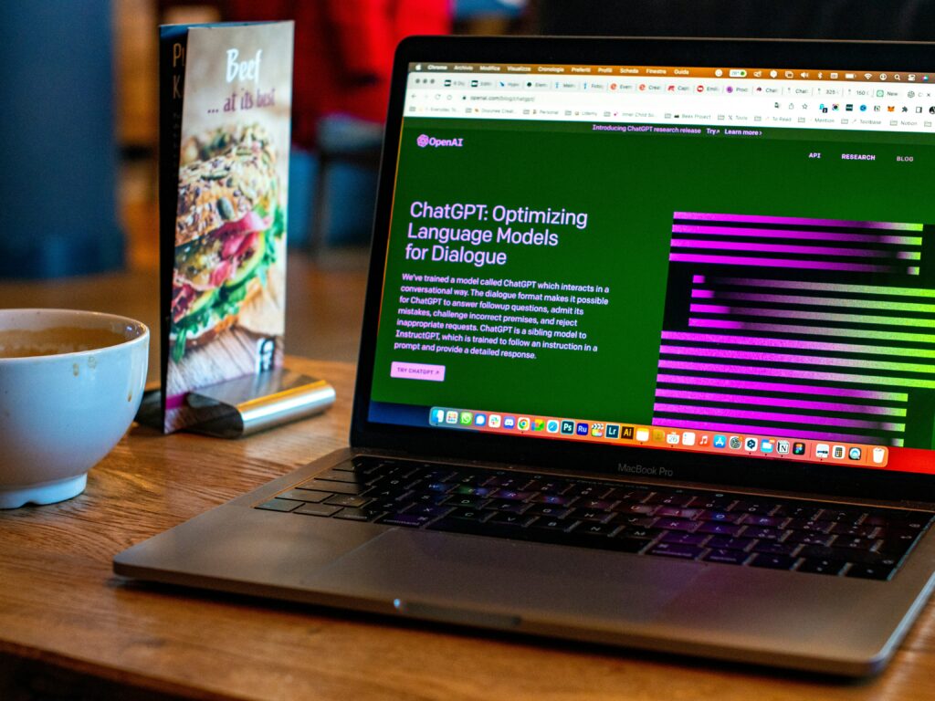 A laptop on a desk. The browser is open  to the ChatGPT homepage.